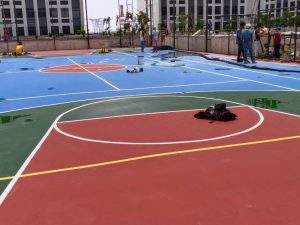 Jasa Pengecatan Lapangan Olahraga Profesional dan BergaransiKondisi warna dan tekstur permukaan lapangan berpengaruh langsung terhadap performa, keindahan, serta keamanan aktivitas olahraga. Seiring waktu, paparan sinar matahari, cuaca ekstrem, dan penggunaan intensif dapat membuat lantai kusam, licin, atau bahkan retak. Solusi Lapangan hadir menawarkan penyedia jasa pengecatan lapangan olahraga profesional dan berpengalaman, siap melayani pengecatan baru maupun repainting (pengecatan ulang) untuk berbagai arena seperti lapangan basket, tenis, voli, bulutangkis, hingga lapangan serbaguna (multipurpose court).Keunggulan & Manfaat Menggunakan Solusi LapanganMenggunakan jasa spesialis pengecatan lapangan olahraga yang profesional berpengaruh besar pada daya tahan warna dan kenyamanan pemain. Berikut adalah manfaat dan keunggulan layanan kami dibanding cat biasa atau penyedia jasa lainnya:Formulasi Cat Acrylic Rubberized Khusus Olahraga: Kami menggunakan cat emulsi berbahan dasar akrilik dengan campuran pasir silika halus dan elastomer yang tahan aus, tidak mudah memudar akibat paparan sinar UV, serta ramah lingkungan.Permukaan Anti-Slip (Non-Slip Surface): Tekstur akhir lapisan dirancang khusus agar tidak licin saat basah maupun kering, memberikan grip maksimal pada sepatu pemain untuk mencegah cedera akibat terpeleset.Tahan Cuaca & Air Menggenang: Lapisan cat memiliki daya rekat tinggi (strong adhesion) pada substrat beton maupun aspal, sehingga tidak mudah mengelupas atau melepuh (blistering) saat terkena perubahan suhu panas dan hujan.Garis Batas Presisi Standar Kompetisi: Pembuatan garis batas permainan (line marking) dilakukan dengan alat ukur presisi tinggi yang sesuai dengan standar federasi olahraga nasional dan internasional.Spesifikasi Detail Produk & Variasi UkuranKami melayani jasa pengecatan lapangan olahraga untuk berbagai variasi jenis dan dimensi area:Lapangan Basket (Full Court): Ukuran standar 28 meter x 15 meter (Luas area pengecatan total ± 420 m² – 600 m² termasuk area margin).Lapangan Tenis (Full Court): Ukuran standar permainan 23,77 meter x 10,97 meter (Luas area pengecatan total ± 600 m² – 670 m² termasuk zona run-off).Lapangan Voli (Full Court): Ukuran standar 18 meter x 9 meter (Luas area pengecatan total ± 280 m² – 360 m² termasuk area batas luar).Lapangan Serbaguna / Multipurpose Court: Ukuran kustom sesuai lahan yang menggabungkan garis batas beberapa cabang olahraga sekaligus (Basket, Voli, & Futsal/Badminton).Spesifikasi Material Cat & Pelapis:Primer Coat / Base Coat: Lapisan pengikat (binder) berbahan akrilik untuk menutup pori-pori beton dan meningkatkan daya rekat cat utama.Silica Rubberized Layer: Campuran cat akrilik dengan pasir silika berbutir halus (silica sand) untuk menciptakan tekstur anti-slip dan meratakan permukaan.Top Coat Color System: Cat warna akrilik berkualitas tinggi yang tahan gesekan dan sinar matahari (aplikasi 2–3 lapis).Line Marking Paint: Cat khusus garis batas yang kontras, tajam, presisi, dan tidak gampang luntur.Tabel Estimasi Harga Jasa Pengecatan Lapangan Olahraga1. Paket Pengecatan Ulang / Repainting (Kondisi Lantai Beton Bagus)Variasi Jenis LapanganPerkiraan Luas AreaEstimasi Biaya PaketLapangan Voli / Bulutangkis± 250 m² – 350 m²Rp 20.000.000 – Rp 30.000.000Lapangan Basket± 420 m² – 550 m²Rp 32.000.000 – Rp 45.000.000Lapangan Tenis± 600 m² – 670 m²Rp 45.000.000 – Rp 60.000.0002. Paket Pengecatan Baru + Sistem Pelapisan Silica Anti-Slip (Standard Full Coating)Variasi Jenis LapanganPerkiraan Luas AreaEstimasi Biaya PaketLapangan Voli / Bulutangkis± 250 m² – 350 m²Rp 30.000.000 – Rp 42.000.000Lapangan Basket± 420 m² – 550 m²Rp 48.000.000 – Rp 65.000.000Lapangan Tenis± 600 m² – 670 m²Rp 65.000.000 – Rp 85.000.000*Catatan: Harga dapat bervariasi tergantung pada kondisi kerusakan permukaan lantai (seperti retak atau berlubang), jumlah kombinasi warna, lokasi proyek, serta persiapan dasar yang dibutuhkan.Tahapan Proses Kerja Solusi LapanganSurvei & Analisis Kelayakan Lantai: Tim kami memeriksa tingkat kelembapan beton, keretakan, dan kebersihan permukaan dasar (floor base).Pembersihan & Perbaikan Permukaan (Floor Preparation): Pembersihan debu, jamur, minyak, serta penambalan retak rambut menggunakan epoxy/acrylic filler.Pengaplikasian Primer (Base Coat): Melapisi lantai dengan cairan primer khusus untuk menyegel pori-pori dan memperkuat ikatan antara beton dan cat.Aplikasi Silica Coating (Tekstur Anti-Slip): Pelapisan campuran cat dan pasir silika secara merata menggunakan rakel (squeegee) khusus.Pengecatan Warna Utama (Top Coat): Pengaplikasian cat warna pilihan sebanyak 2–3 lapis hingga menutup sempurna dan warna terlihat tajam.Penarikan Garis Batas (Line Marking): Pembuatan garis lapangan sesuai standar ukuran cabang olahraga yang dipilih dengan garis yang rapi dan tegas.Quality Control & Serah Terima: Inspeksi ketebalan, kerapihan, dan waktu pengeringan sebelum lapangan siap dipergunakan.Area Layanan Solusi LapanganKami melayani jasa pengecatan dan renovasi lapangan olahraga secara profesional untuk wilayah Jakarta, Bogor, Depok, Tangerang, Bekasi (Jabodetabek), Subang, dan Bandung.Panduan Perawatan dan PemeliharaanPembersihan Rutin: Bersihkan sampah, daun kering, dan debu secara teratur menggunakan sapu lembut atau blower.Pencucian Berkala: Cuci lapangan dengan air bersih mengalir untuk menghilangkan sisa lumpur atau kotoran yang menempel.Penggunaan Sepatu Sesuai: Himbau pengguna untuk selalu memakai sepatu olahraga bertapak karet lunak (non-marking shoes).Hindari Benda Tajam & Kimia Keras: Dilarang menggunakan pembersih berbahan asam kuat atau menggeser benda berat berkaki tajam di atas permukaan cat.Informasi & Cara PemesananPerbarui tampilan lapangan olahraga Anda agar kembali indah, aman, dan nyaman digunakan bersama tim ahli kami.Hubungi Bpk Adam di nomor 081315151013 (Telepon/WhatsApp) untuk berkonsultasi mengenai skema warna, jadwal survei lokasi, serta penawaran harga terbaik.FAQ (Frequently Asked Questions)Berapa lama waktu kering cat lapangan olahraga hingga siap dimainkan?Proses pengeringan sentuh memakan waktu beberapa jam, namun disarankan untuk membiarkan cat curing sempurna selama 48–72 jam sebelum lapangan dipakai untuk aktivitas olahraga intensif.Apakah cat khusus lapangan olahraga ini bisa dipakai untuk lapangan indoor dan outdoor?Ya, formulasi cat acrylic rubberized yang kami gunakan sangat fleksibel dan dirancang khusus tahan sinar matahari outdoor maupun kelembapan area indoor.Apakah Solusi Lapangan memberikan garansi pengerjaan?Tentu saja, kami memberikan garansi pengerjaan untuk memastikan cat tidak cepat mengelupas akibat kesalahan teknis aplikasi.